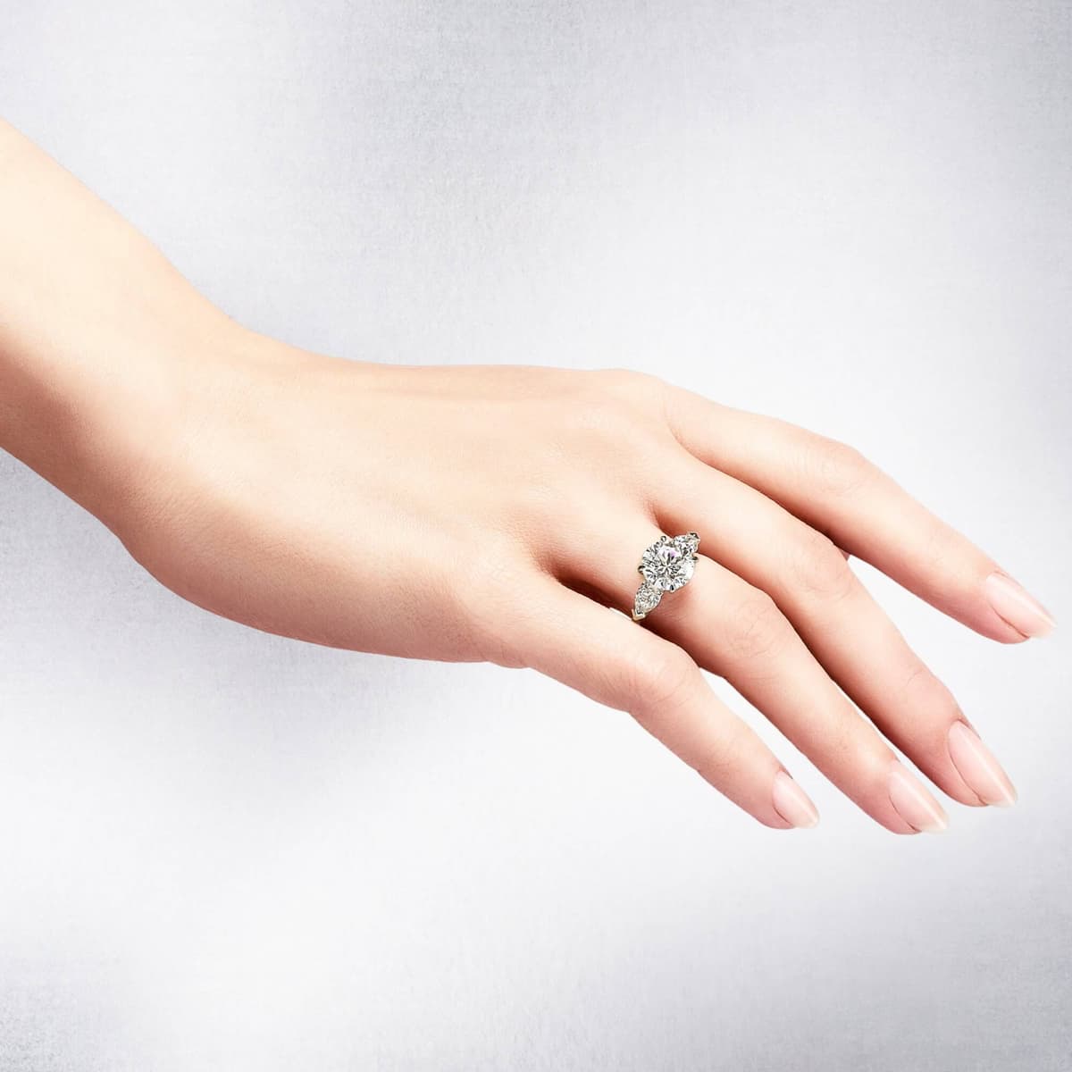 Hand wearing a round brilliant cut diamond ring